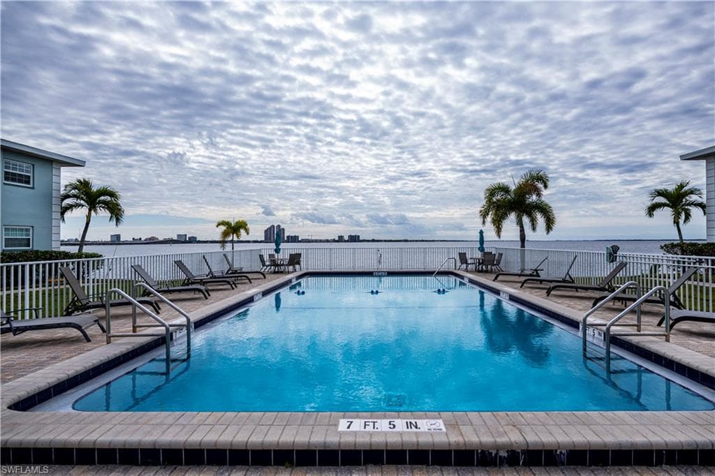 View of pool featuring a water view and a patio
