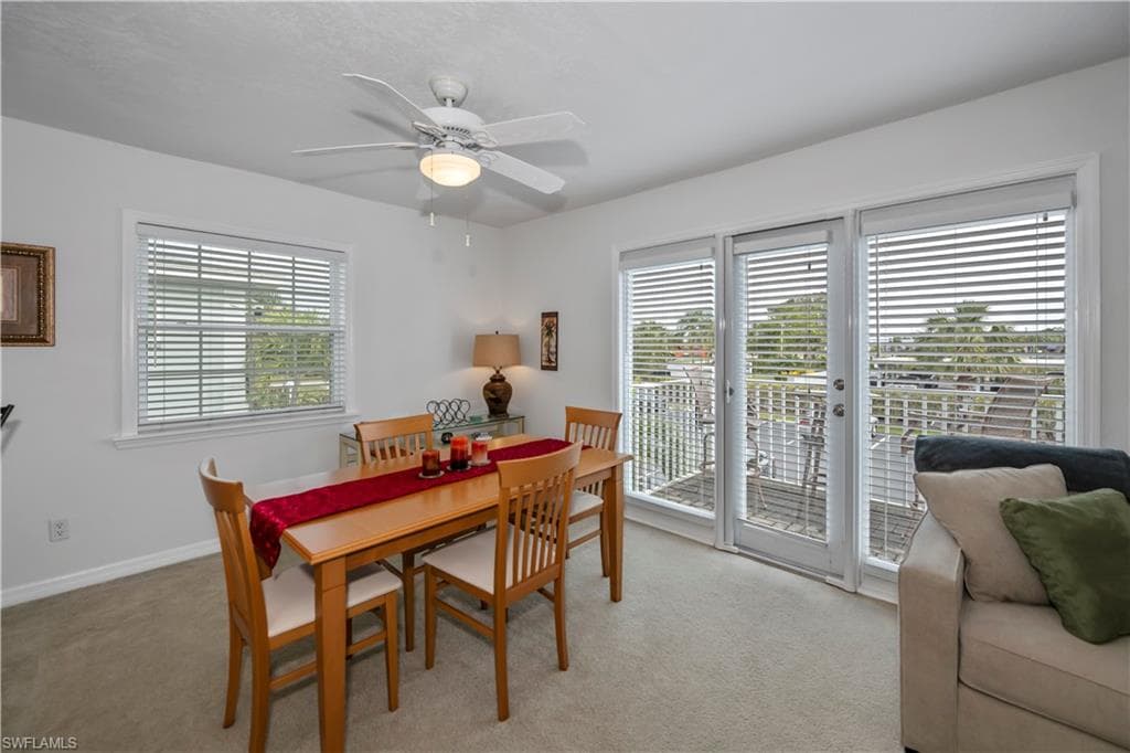 Dining area featuring light carpet and ceiling fan
