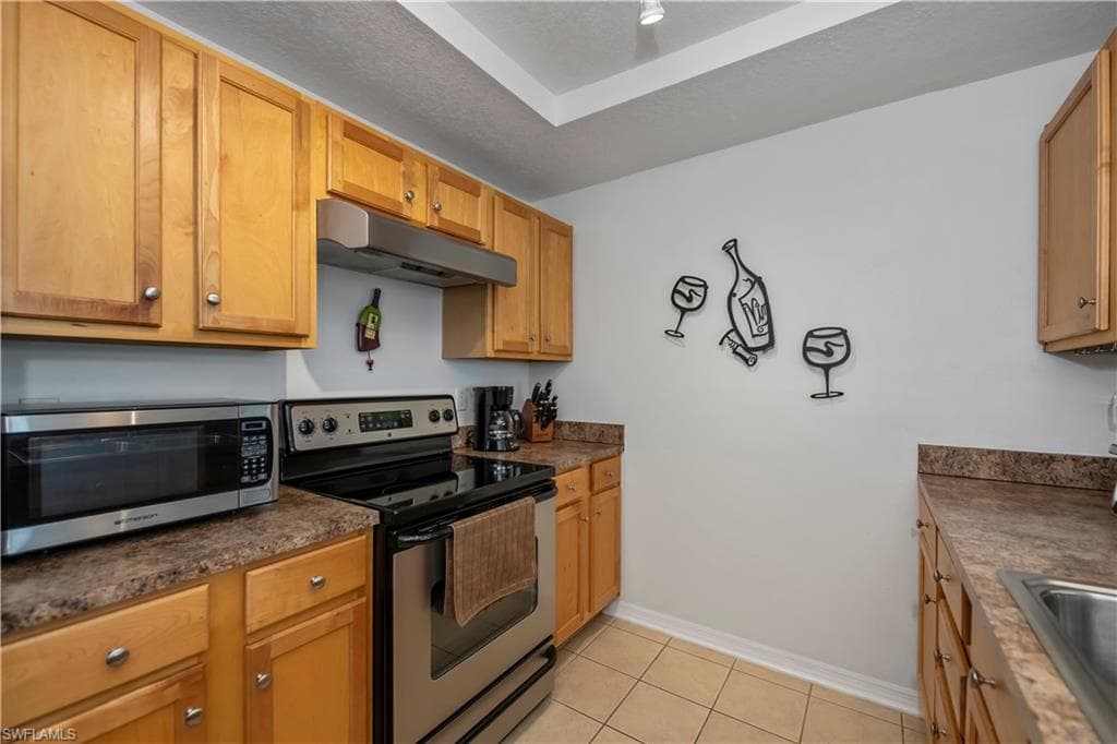 Kitchen with light tile patterned flooring and stainless steel appliances