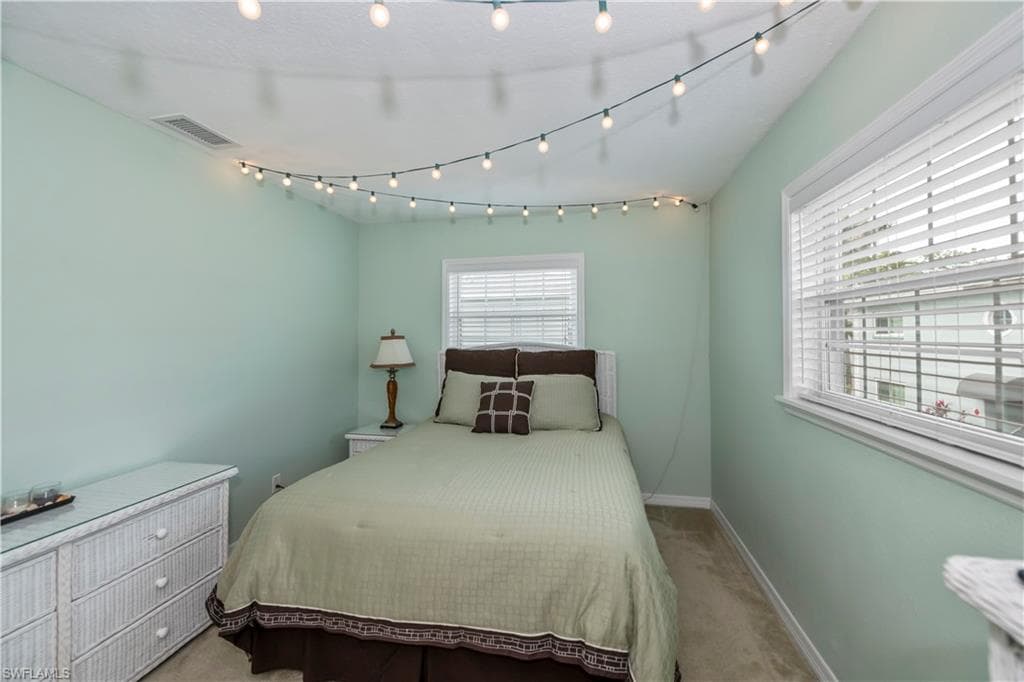 Bedroom featuring light carpet