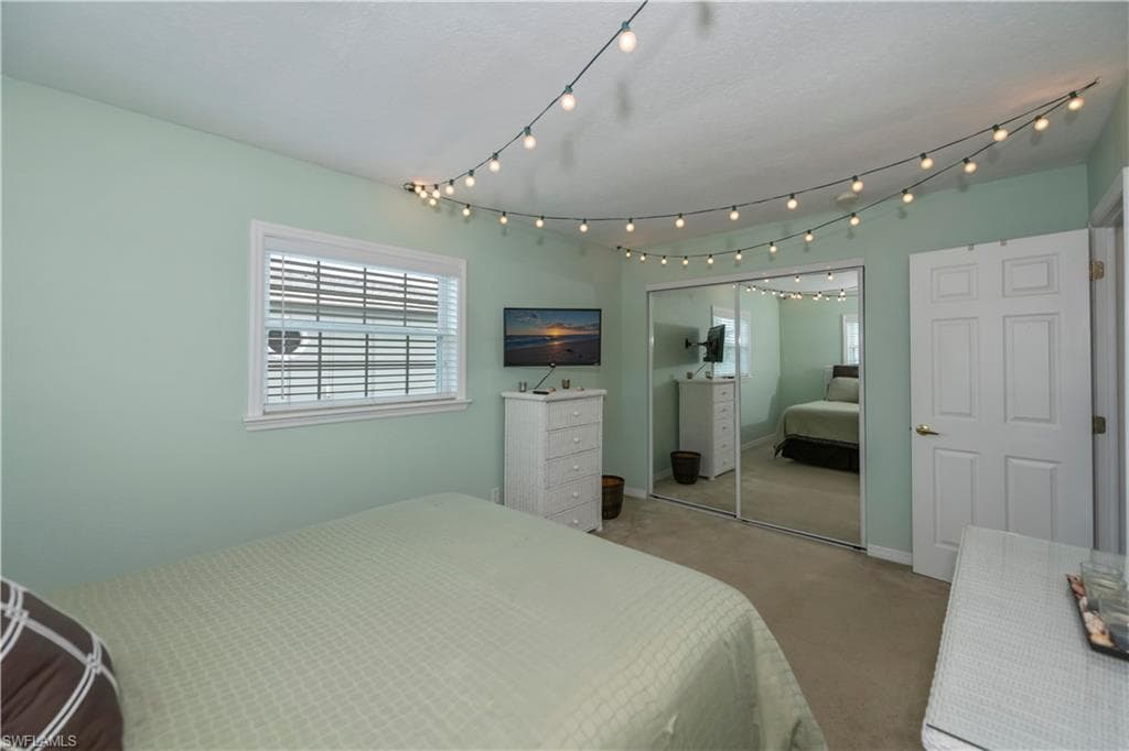 Carpeted bedroom featuring a closet