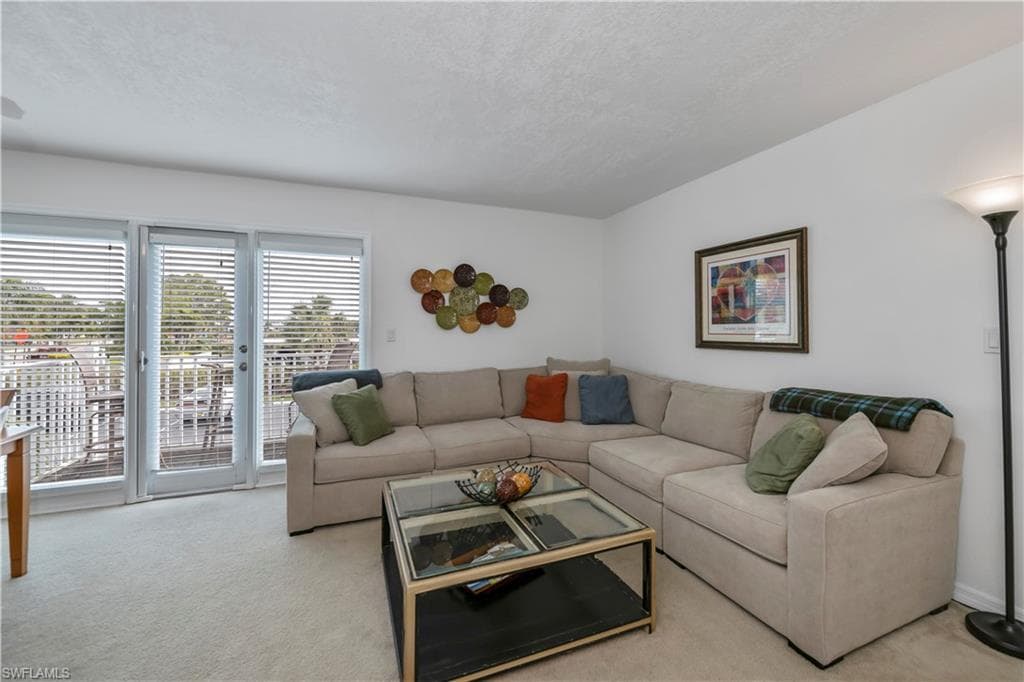 Living room featuring light colored carpet and a textured ceiling