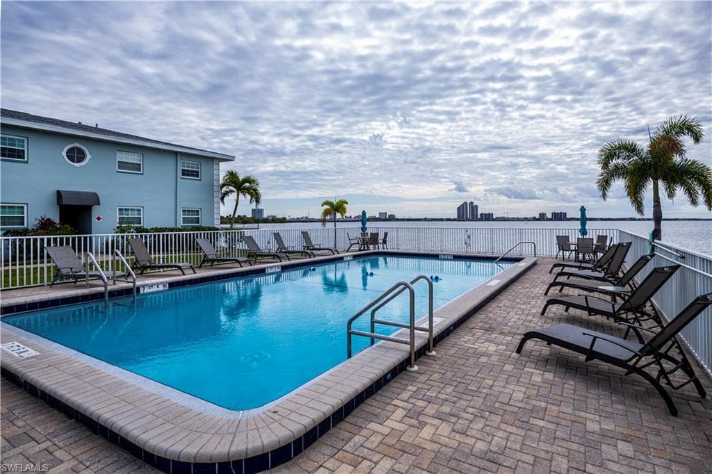 View of pool featuring a water view and a patio area