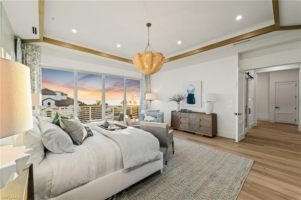Bedroom featuring light wood-style flooring, recessed lighting, a chandelier, a barn door, and ornamental molding