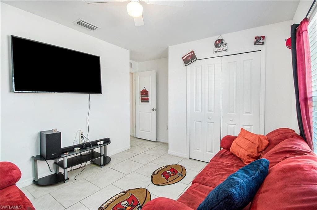 Living room featuring light tile patterned flooring and ceiling fan