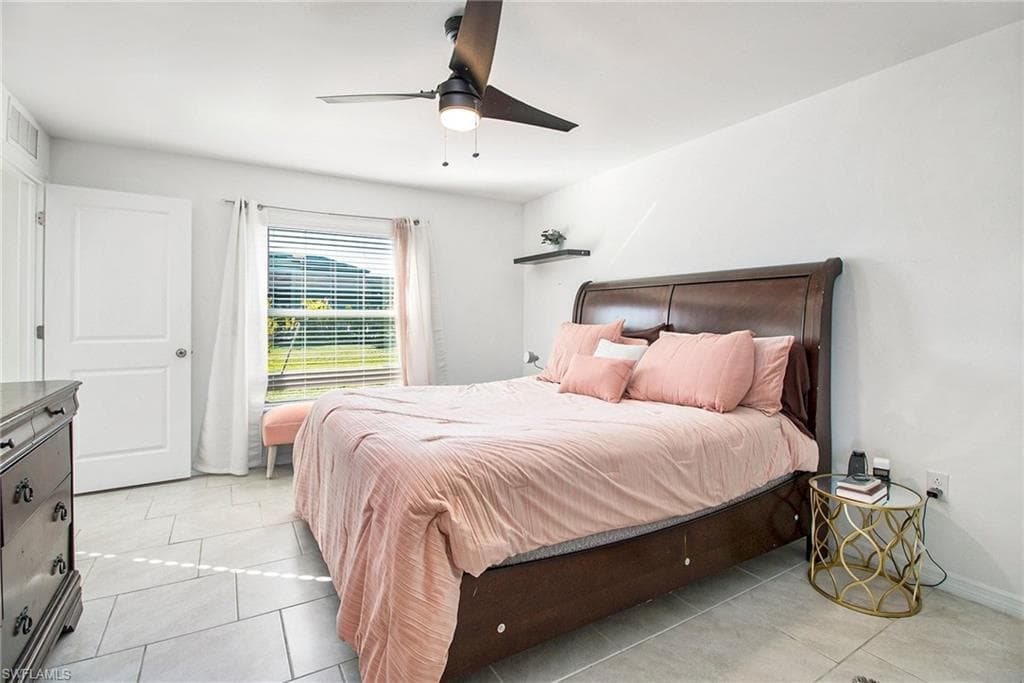 Bedroom with ceiling fan and light tile patterned flooring