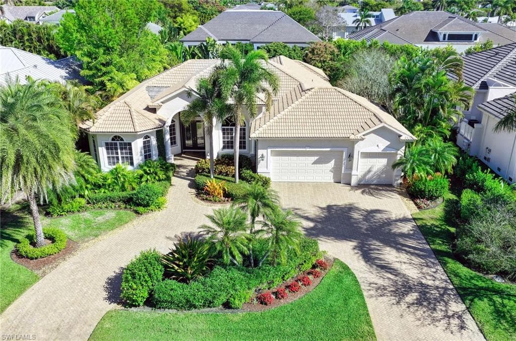 View of front of house featuring a tile roof, decorative driveway, an attached garage, and stucco siding
