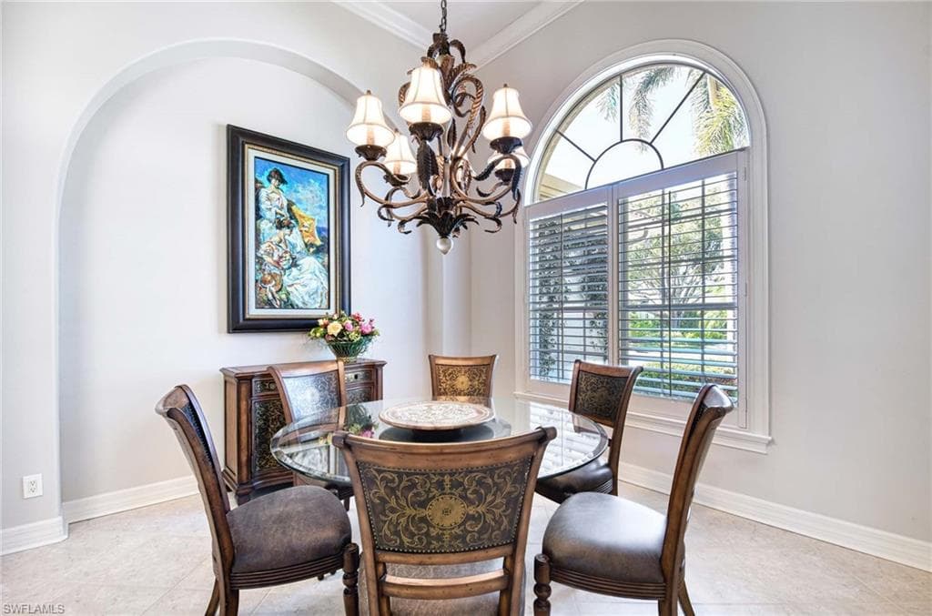 Dining space featuring a chandelier, ornamental molding, and light tile patterned flooring