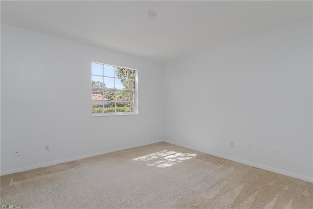 Unfurnished room featuring light colored carpet and baseboards