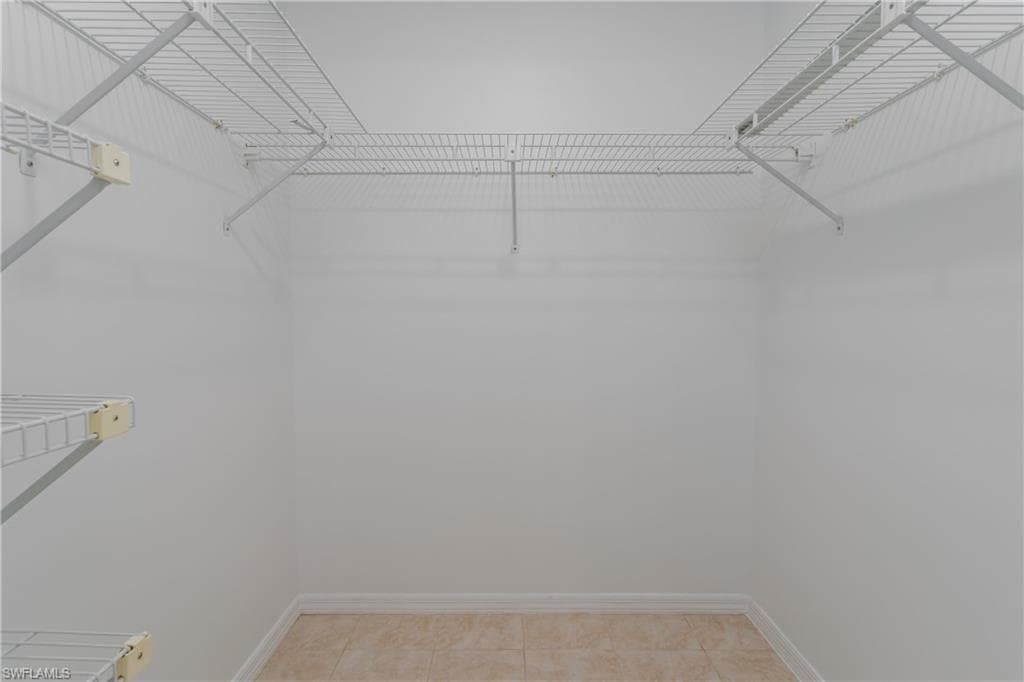 Walk in closet with light tile patterned floors