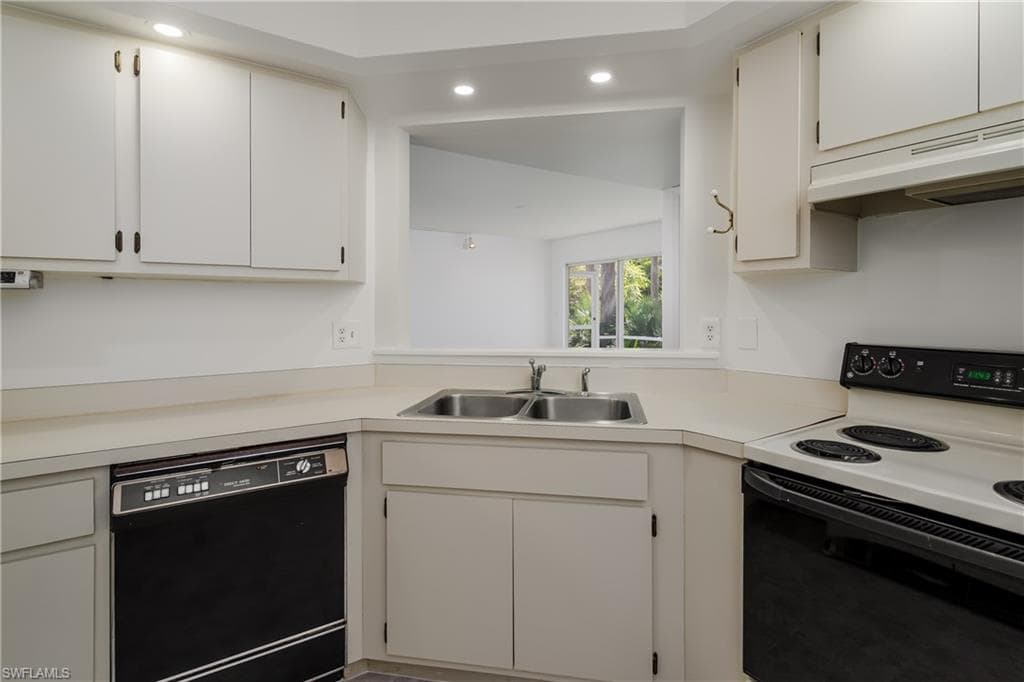Kitchen featuring range with electric stovetop, black dishwasher, light countertops, recessed lighting, and white cabinetry