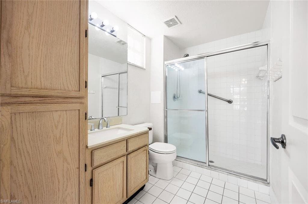 Bathroom featuring vanity, shower, and light tile patterned floors