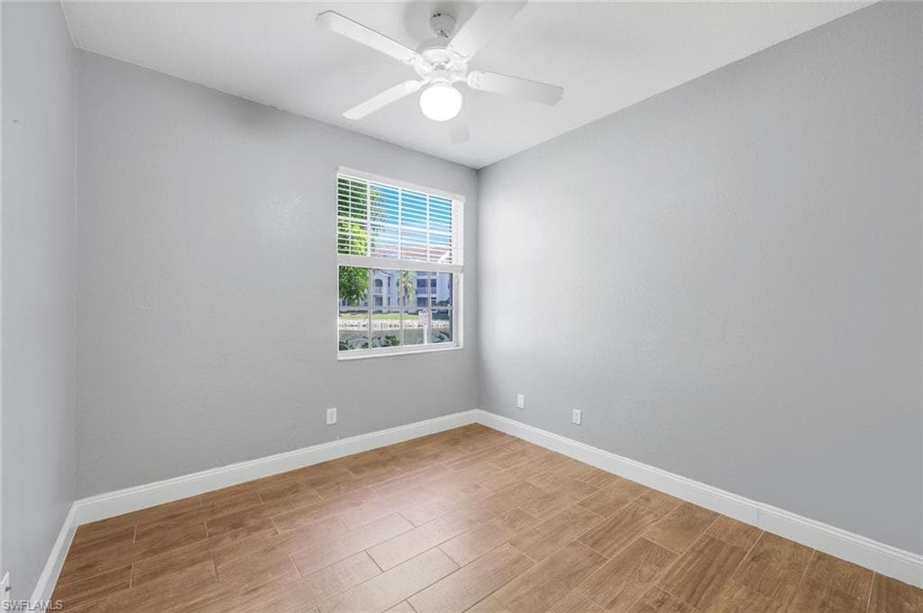 Bedroom with wood finish floors, ceiling fan and lakeview