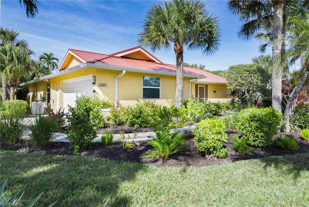 View of property exterior featuring an attached garage, stucco siding, and a lawn