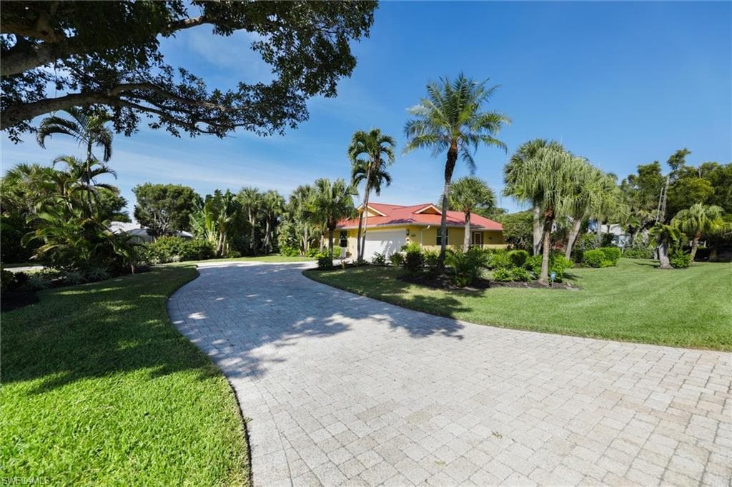 View of front of home featuring a front lawn and decorative driveway