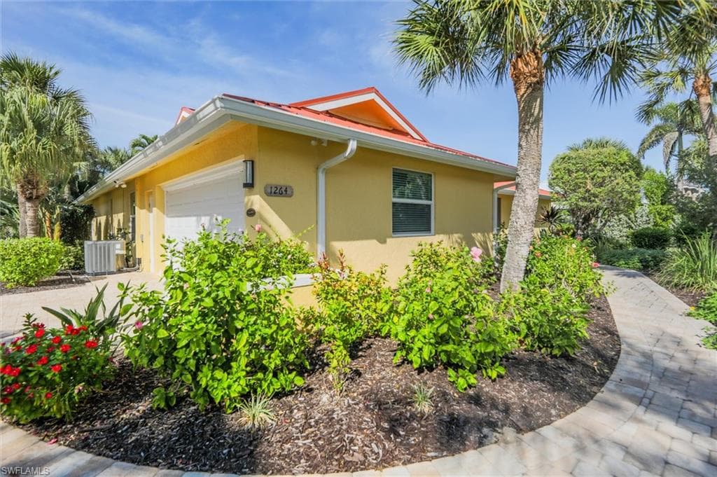 View of property exterior featuring an attached garage and stucco siding