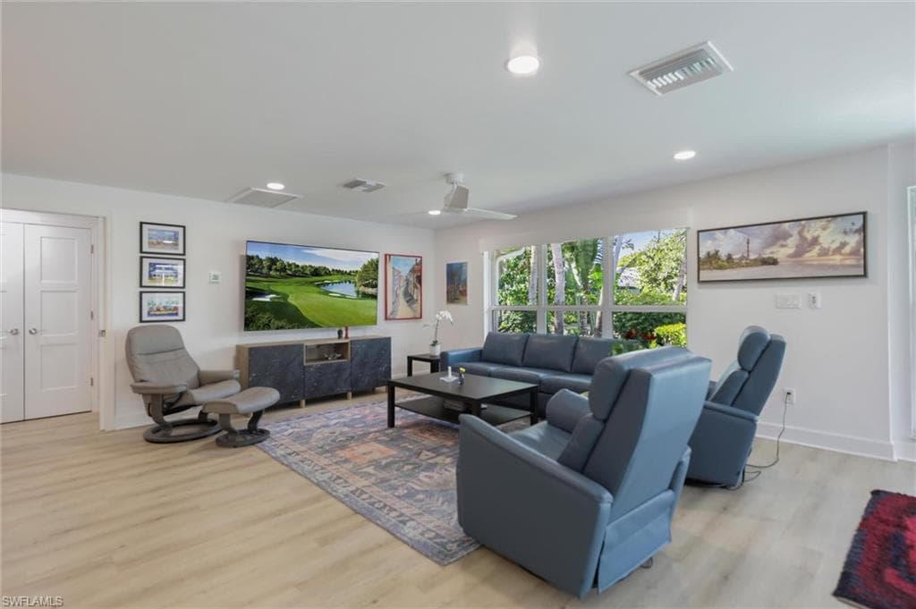 Living area featuring light wood finished floors and recessed lighting