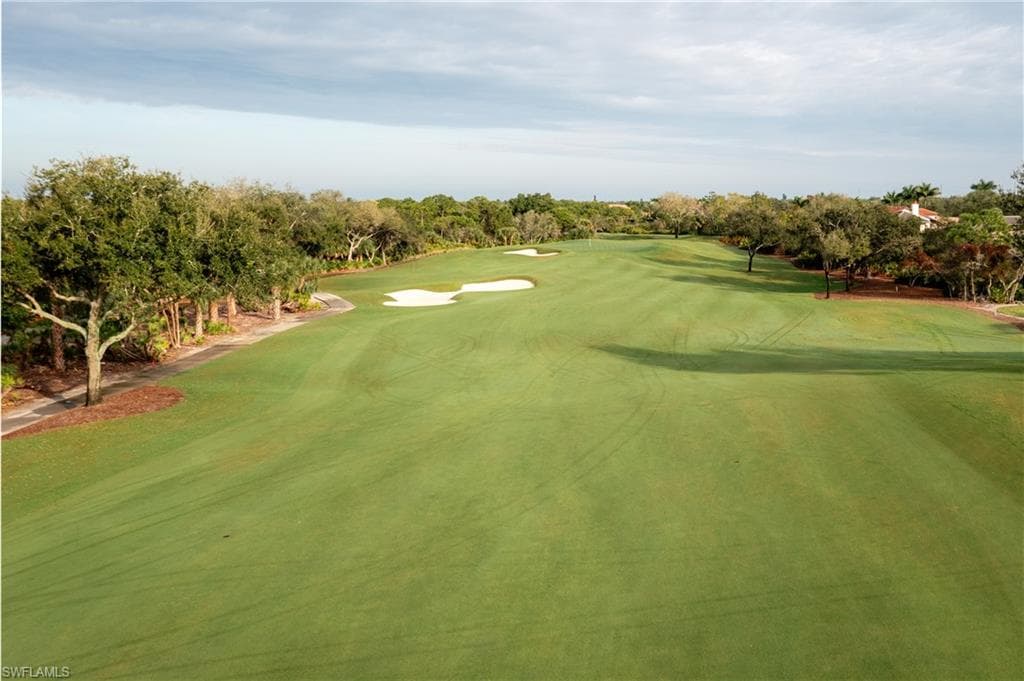 View of property's community with golf course view and view of scattered trees