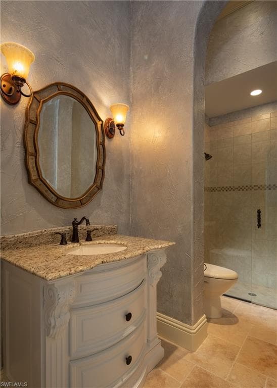 Full bathroom with vanity, a stall shower, and a textured wall