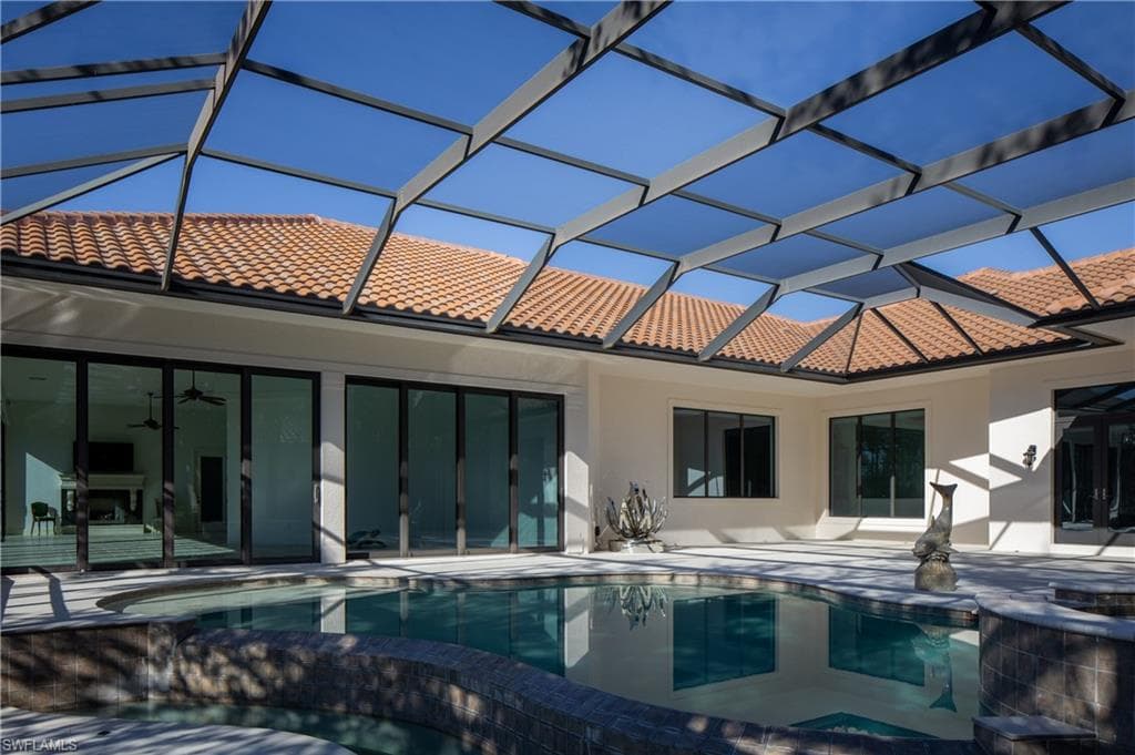 View of pool with an infinity pool, a lanai, a sunroom, and a patio area