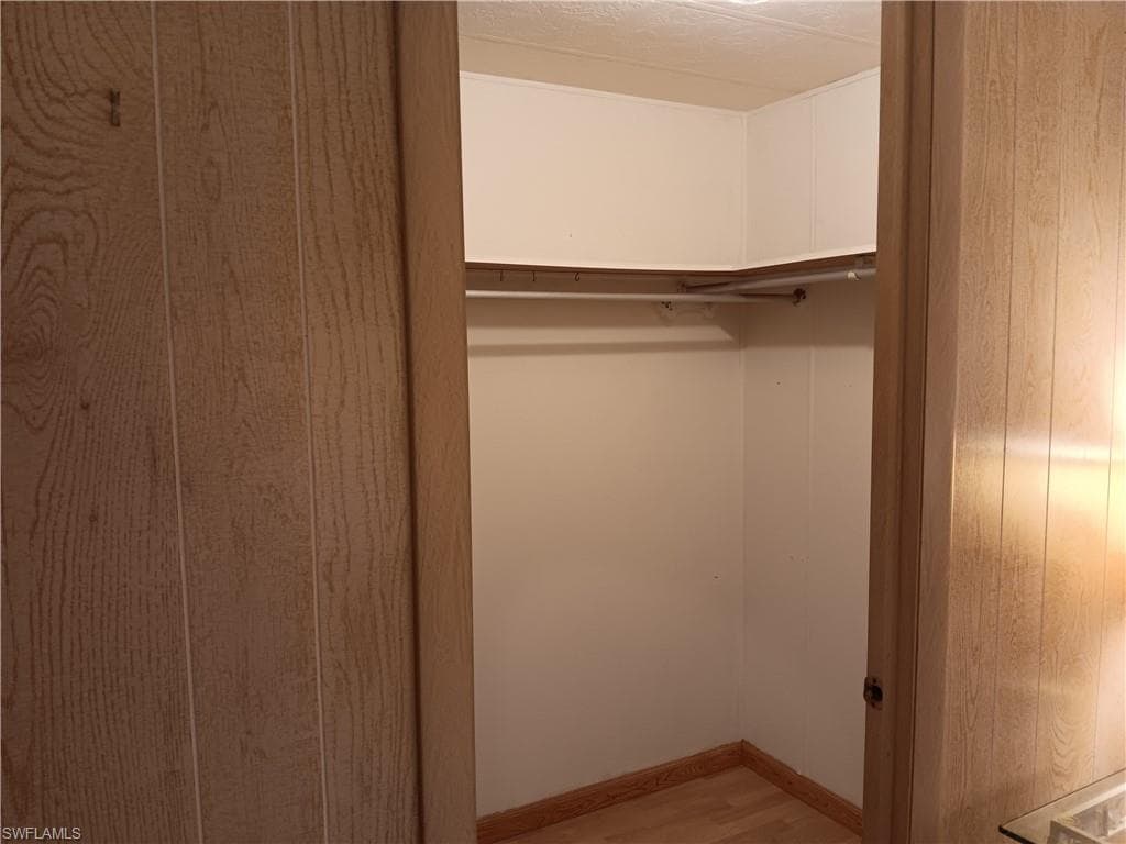 Bedroom featuring wood finished floors and wood walls