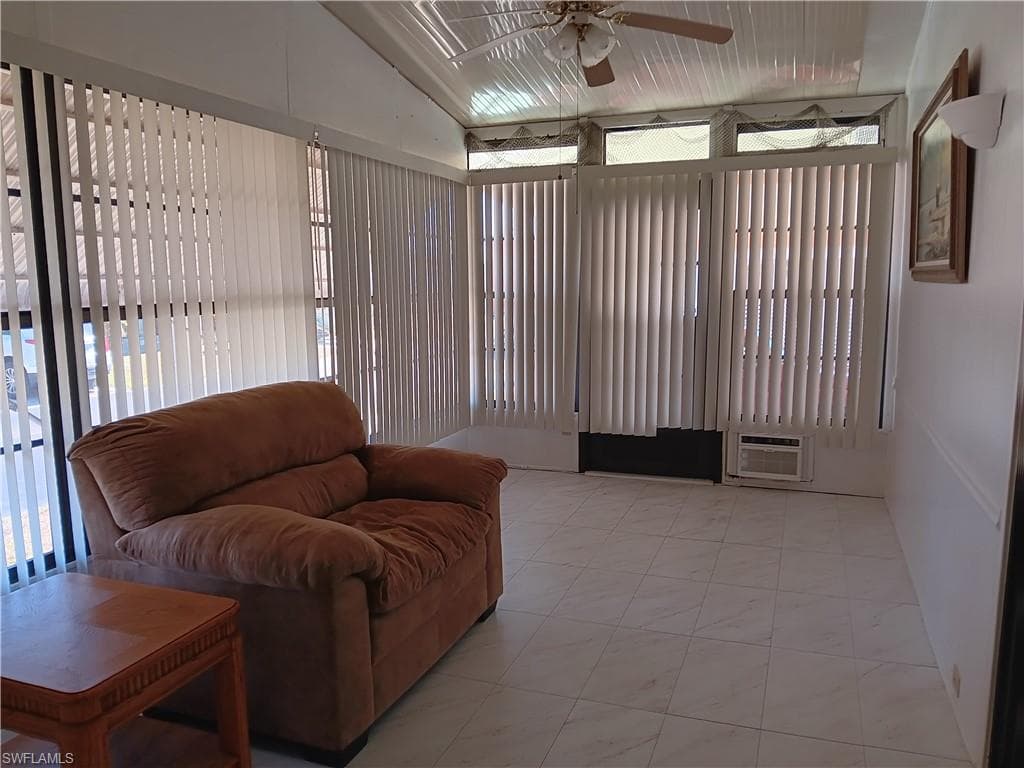 Bedroom featuring wood finished floors, a walk in closet, wooden walls, and a ceiling fan