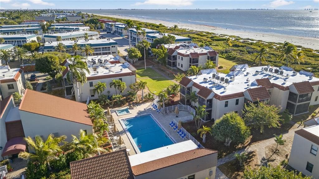 Bird's eye view of waterfront with a beach and a pool area