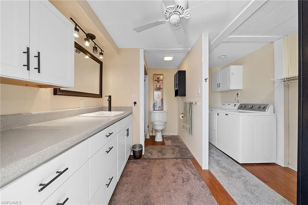 Full bath with vanity, independent washer and dryer, ceiling fan, and a walk in closet