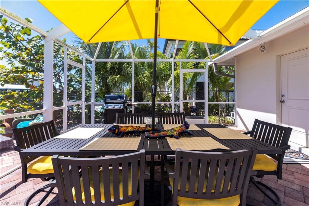View of patio / terrace featuring a lanai, grill, and outdoor dining space