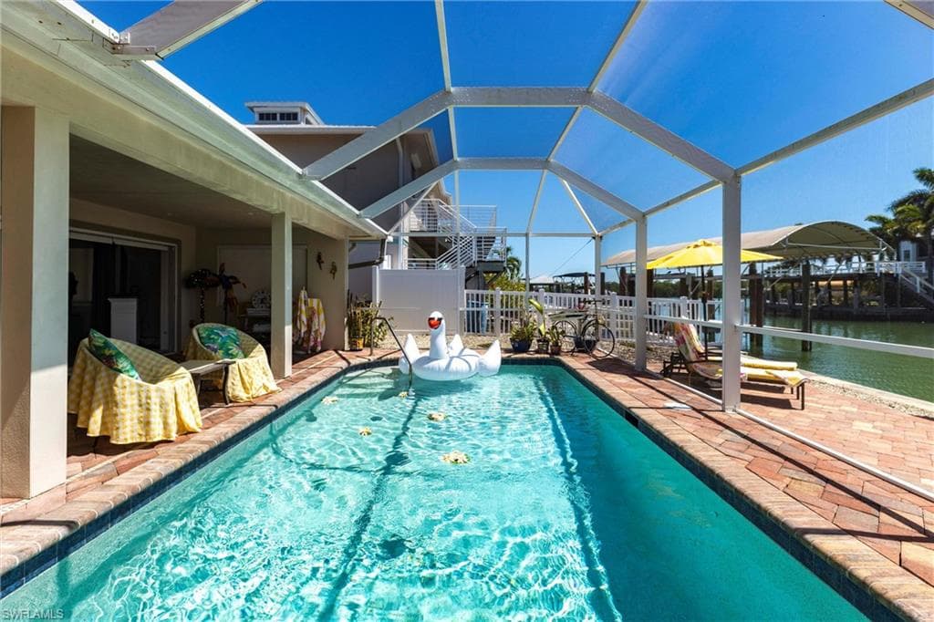 View of swimming pool, a lanai, a patio, and a water view