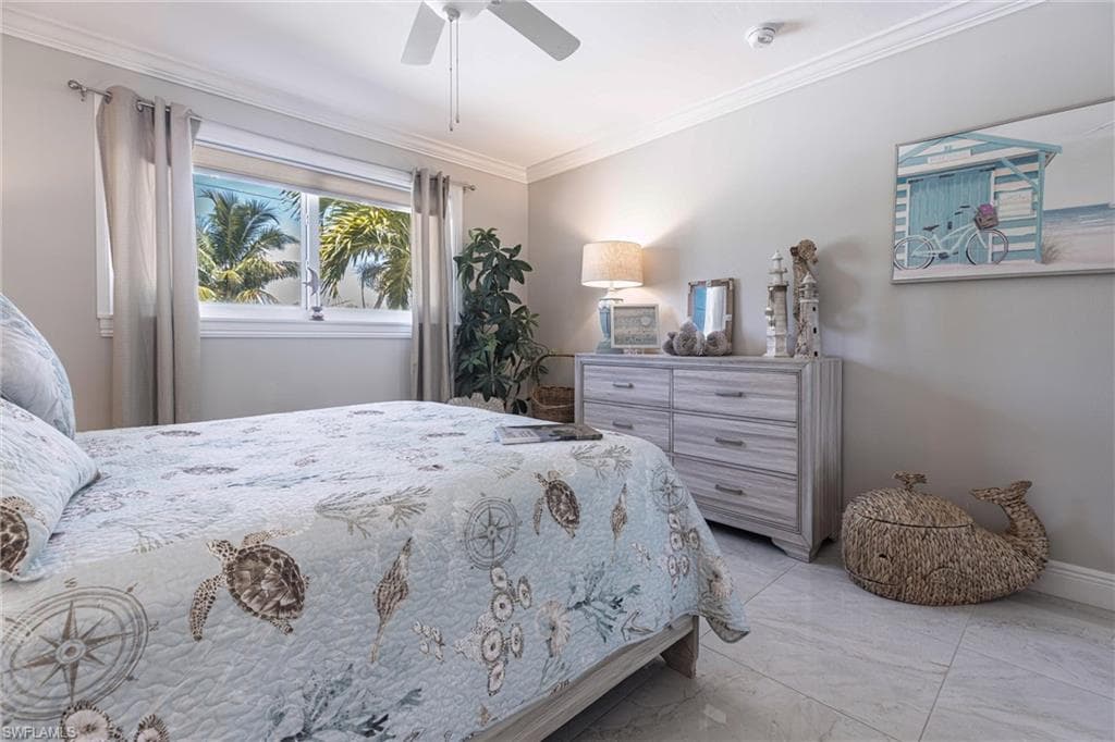 Bedroom with baseboards, marble finish floor, ornamental molding, and ceiling fan