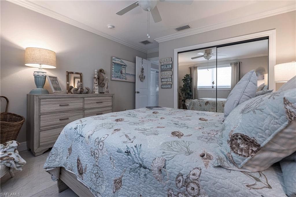 Bedroom with crown molding, a closet, ceiling fan