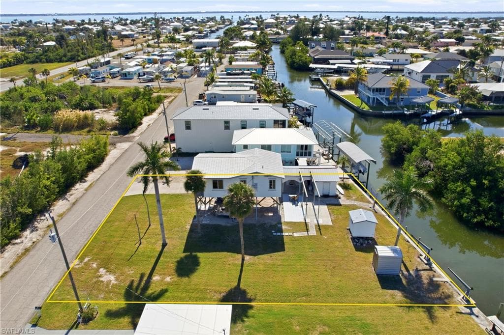 Aerial view of canal to open water. Home and additional lot shown in yellow.