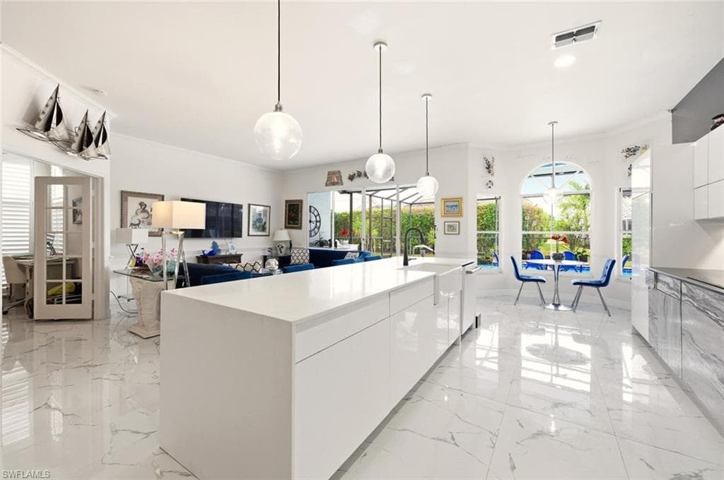 Kitchen featuring modern cabinets, white cabinets, open floor plan, and pendant lighting