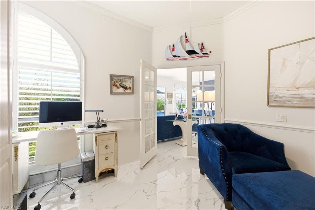 Office area featuring french doors, crown molding, and light marble finish flooring