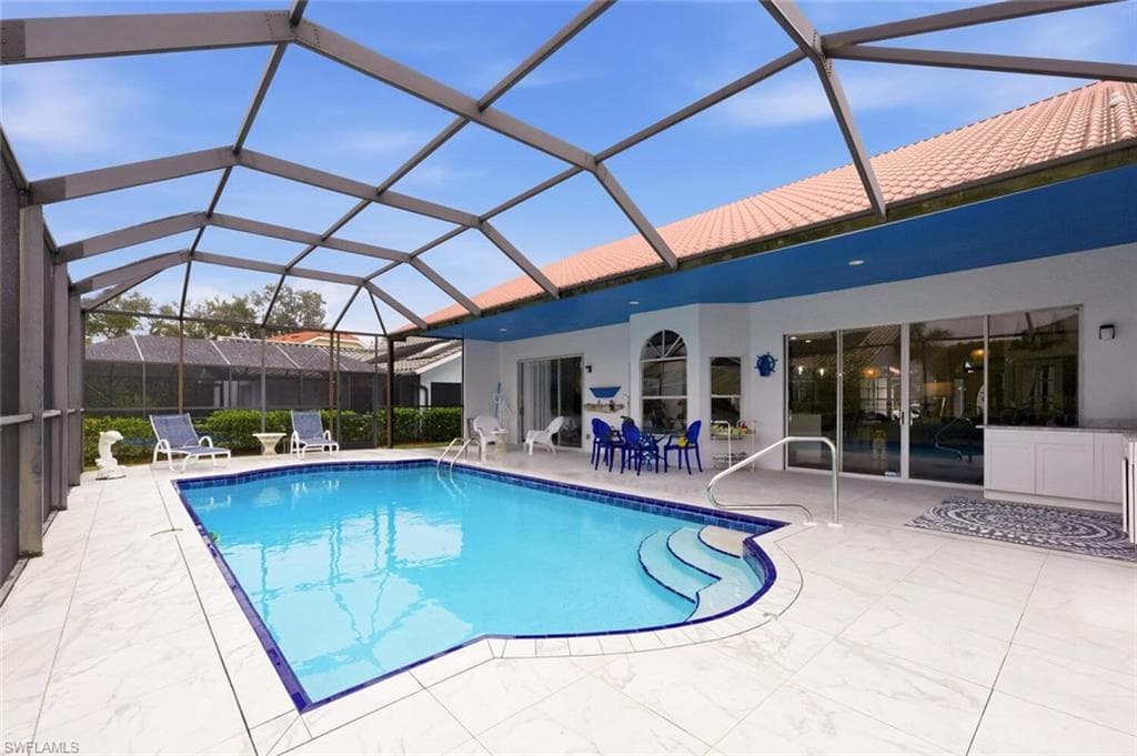 Outdoor pool with a sunroom, glass enclosure, and a patio