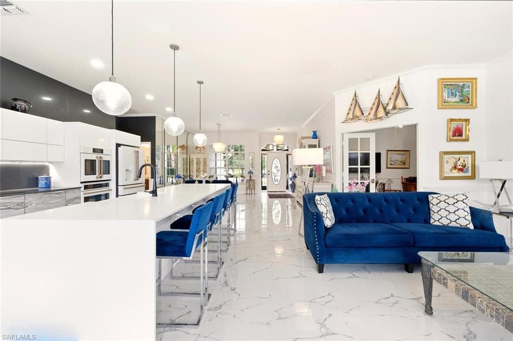 Living room featuring light marble finish floors and crown molding