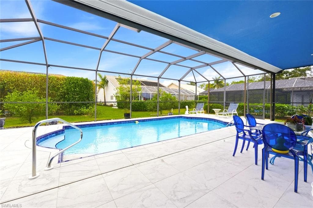 Outdoor pool featuring a sunroom, a lanai, a yard, and a patio area
