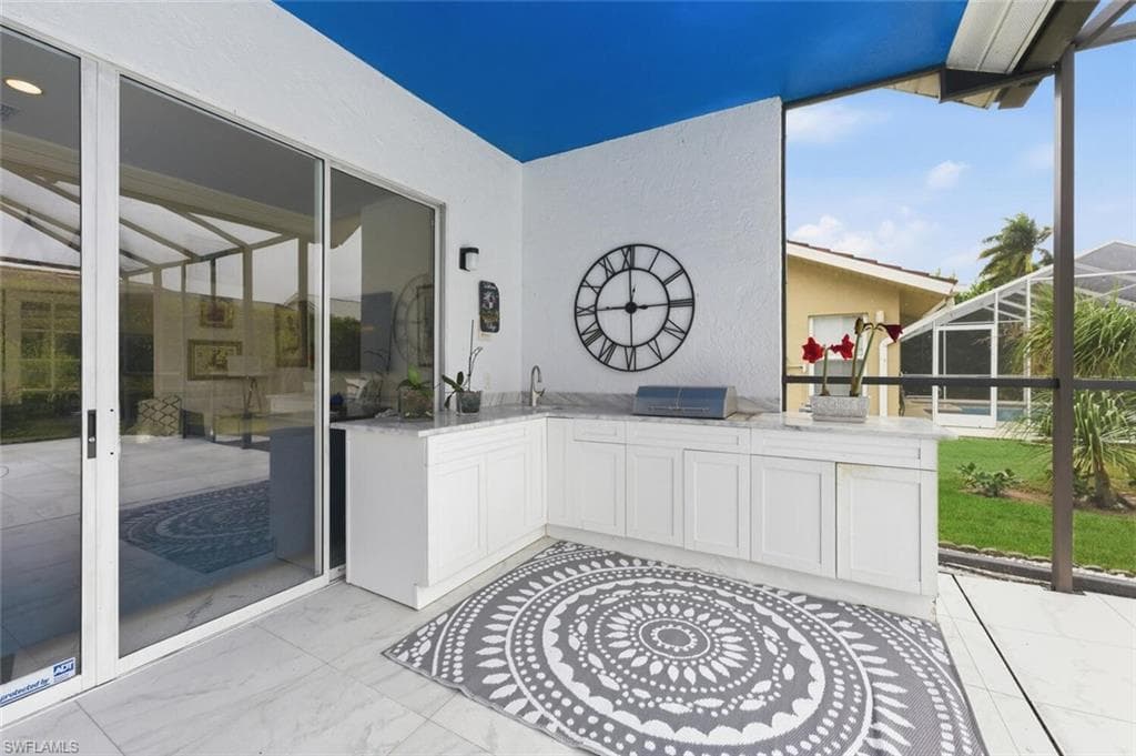 View of patio with a lanai, a sunroom, and area for grilling