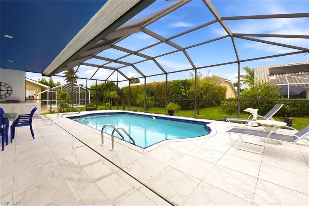 Outdoor pool with a sunroom, a lanai, a patio, and a lawn