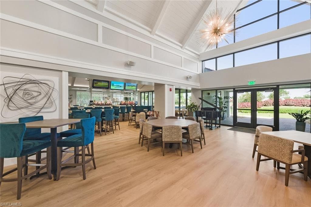 Dining space featuring french doors, light wood-type flooring, lofted ceiling, and suspended lighting