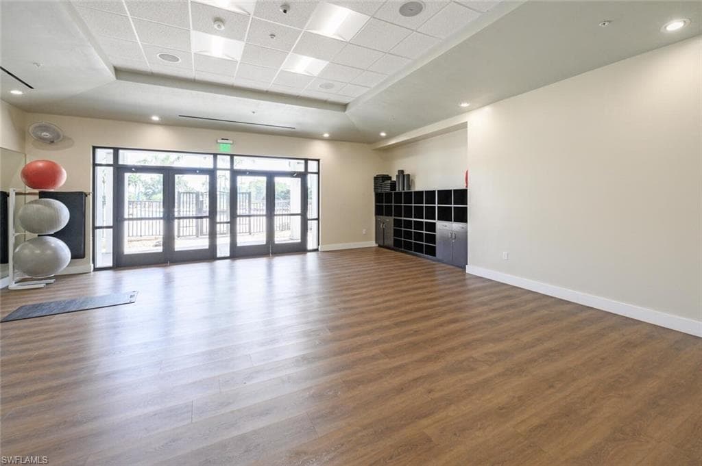 Workout room featuring a tray ceiling and a paneled ceiling