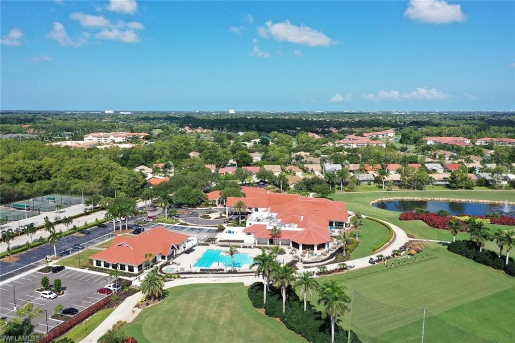 Aerial view of property and surrounding area featuring a nearby body of water and a golf club