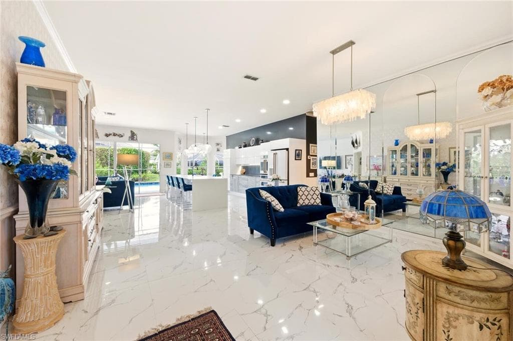 Living area with hanging lights and light marble finish flooring