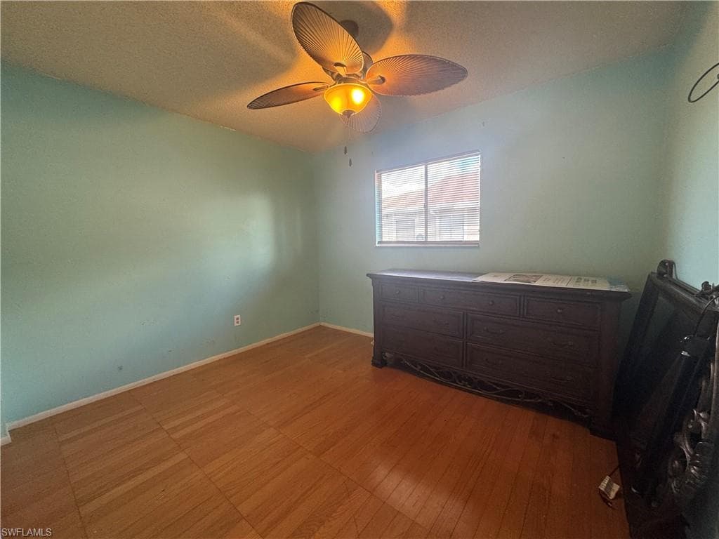 Unfurnished bedroom with a ceiling fan and a textured ceiling