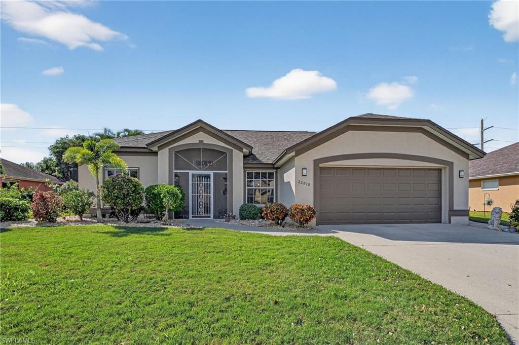 Ranch-style home featuring stucco siding, a front lawn, concrete driveway, a garage, and a shingled roof