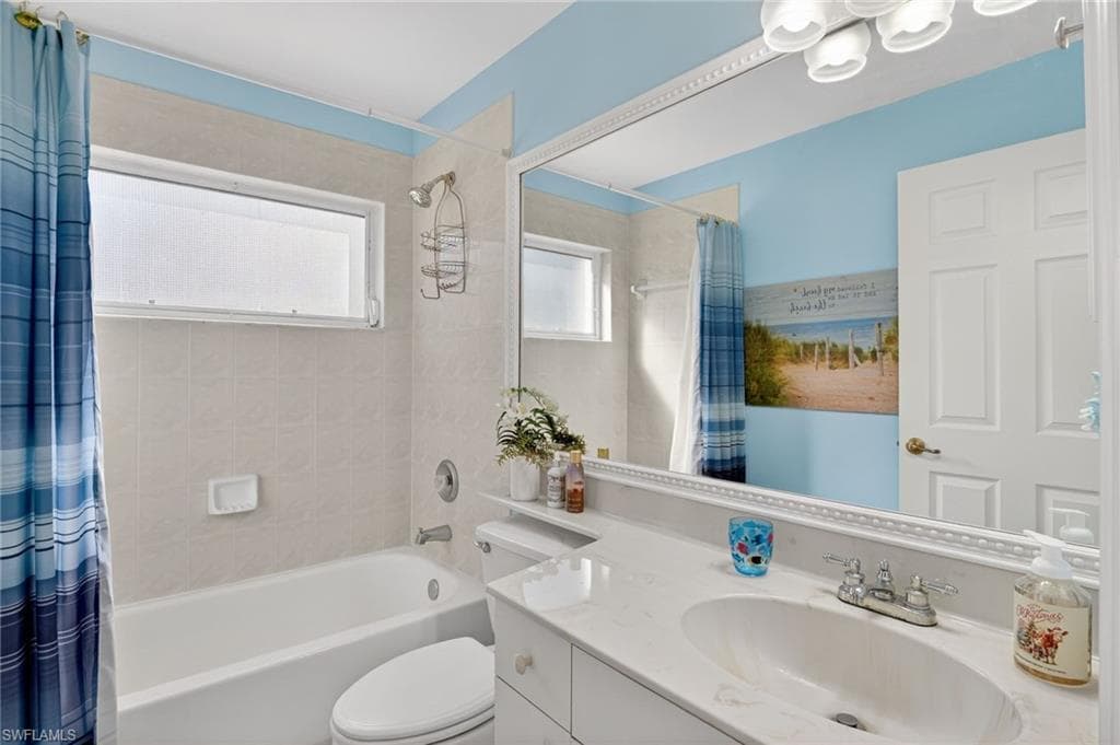 Full bathroom with shower / bath combo with shower curtain and vanity