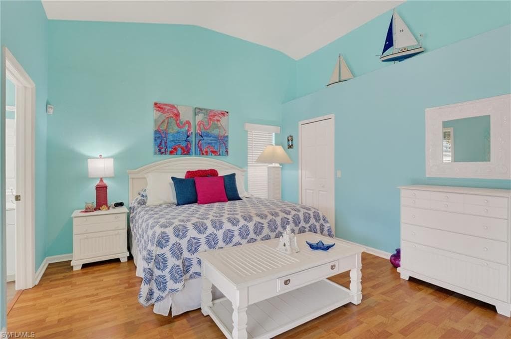 Bedroom with light wood-type flooring and vaulted ceiling