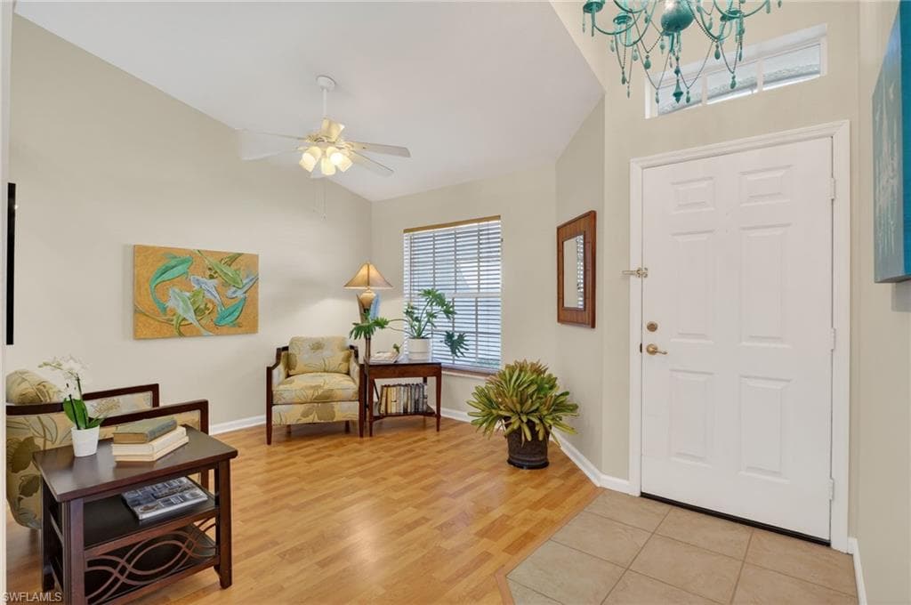 Entrance foyer featuring light wood finished floors, vaulted ceiling, and a ceiling fan
