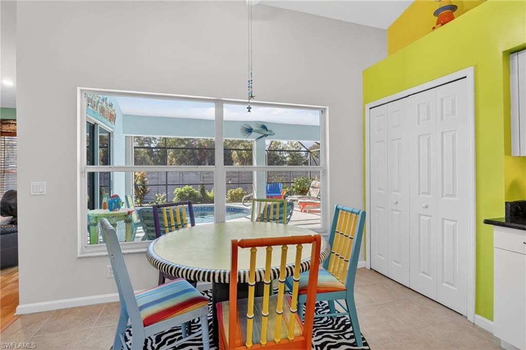 Dining room featuring light tile patterned floors and high vaulted ceiling